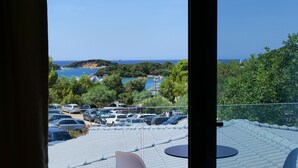 Ein Balkon mit Blick auf einen Parkplatz und ein Gewässer.