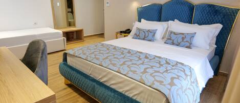 A hotel room with a bed, a desk, and a chair.