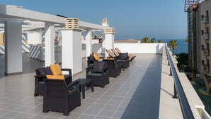 A rooftop terrace with outdoor seating, a pool, and a view of the ocean. - Hotel Perla Del Sur (Torremolinos)