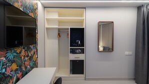 A modern bedroom with a white wardrobe, a mirror, and a television on the left wall. - Hotel Perla Del Sur (Torremolinos)
