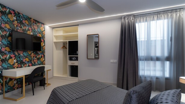 A modern bedroom with a bed, a desk, and a wardrobe. - Hotel Perla Del Sur (Torremolinos)