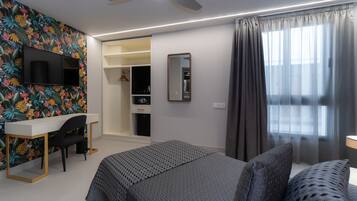 Een moderne slaapkamer met een bed, een bureau en een kledingkast.