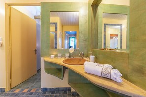 A bathroom with a wooden vanity, a round sink, a mirror, and a towel. - Villa Revita Kourouta Beach (Ilida)