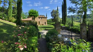 Une maison en pierre avec un chemin de jardin menant à un portail.