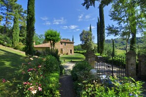 A stone house with a garden path leading to a gate.