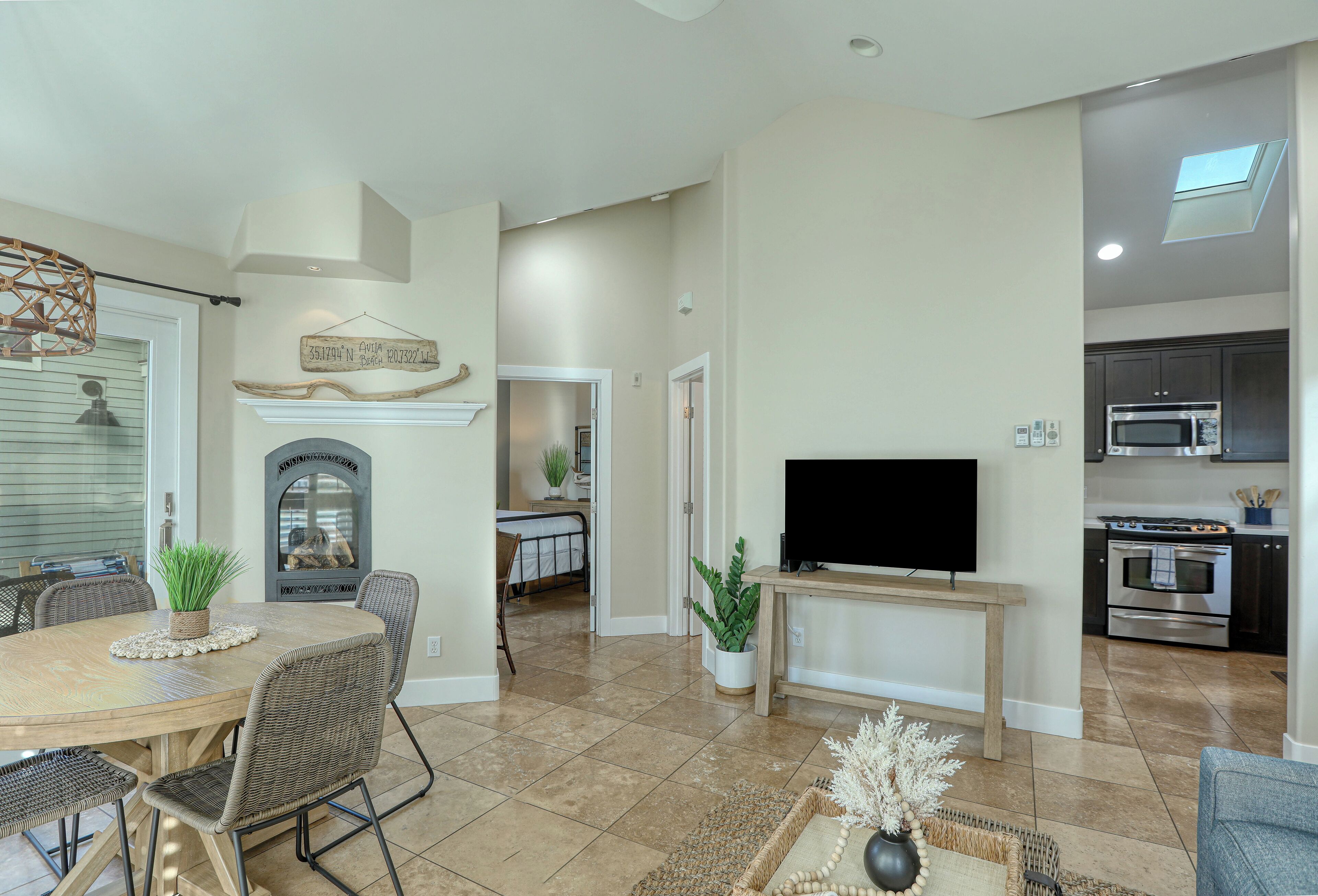 A spacious living room with a dining area, a TV, and a kitchen.