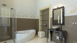 Une salle de bain moderne dotée d’une douche à parois de verre, d’une baignoire sur pieds, d’un meuble-lavabo avec un plan de travail en marbre et d’un grand miroir.