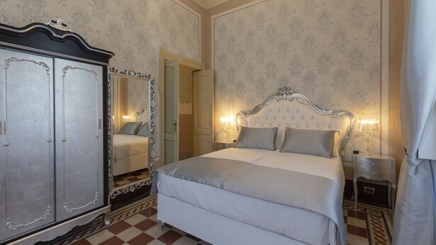 Une chambre à coucher avec un grand lit, une armoire et un miroir.