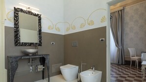 Une salle de bain moderne avec un meuble-lavabo en marbre, un grand miroir, un bidet et des toilettes.