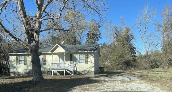 A single-story house with a porch and a small staircase leading to the front door.