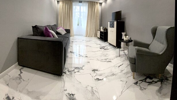 A modern living room with a sofa, armchair, and a TV on a cabinet. - Perfect location (Minsk)