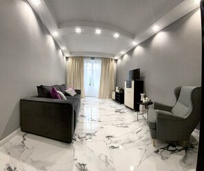 A modern living room with a sofa, armchair, and a TV on a cabinet. - Perfect location (Minsk)
