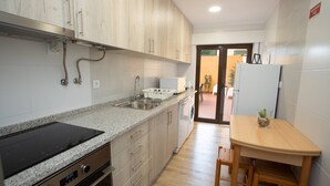 A modern kitchen with granite countertops, stainless steel appliances, and wooden cabinets. - Meriteluna Pateo - beetwen Lisboa Sintra e Cascais (Agualva-Cacém)