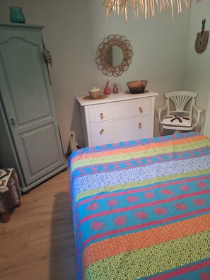 Ein Schlafzimmer mit einem Bett, einem Schminktisch, einem Stuhl und einem Kleiderschrank.