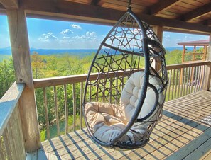 A hanging chair on a wooden deck with a view of a mountainous landscape. - Beautiful Mountain/Lake Views! Hot Tub & Pool Table (Sevierville)