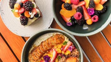 Tres tazones de ensalada de frutas con diversas bayas y frutas.