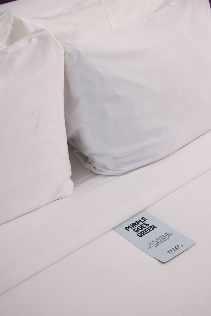 Una cama bien hecha con una almohada y una etiqueta en la colcha.