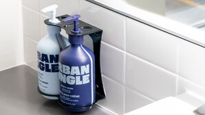 Two bottles of hand soap and a hand sanitizer on a bathroom counter. - YOTEL Miami (Miami)
