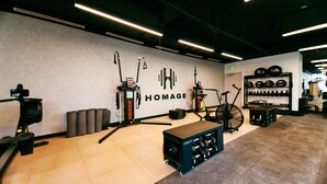 A gym with exercise equipment, a wall-mounted weight rack, and a bench. - YOTEL Miami (Miami)