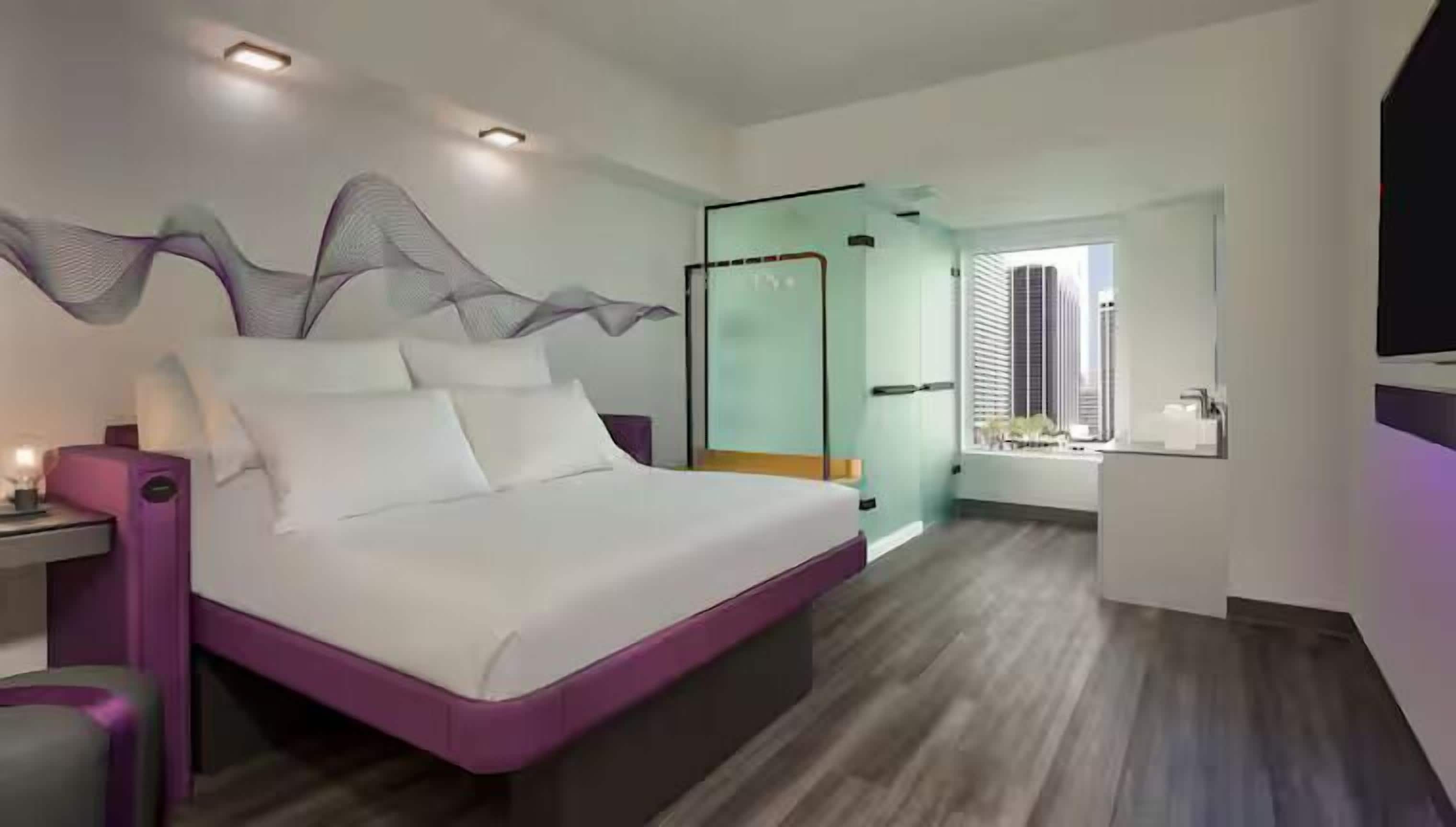 Ein modernes Schlafzimmer mit einem großen Bett, einem Nachttisch und einer Dusche mit Glaswand.