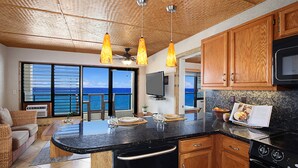 Una cocina moderna con armarios de madera, una estufa negra y una isla grande.