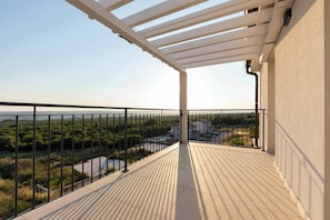 A balcony with a view of a green landscape and a building in the distance. - Villa Lumina (Sveti Lovrec Labinski)