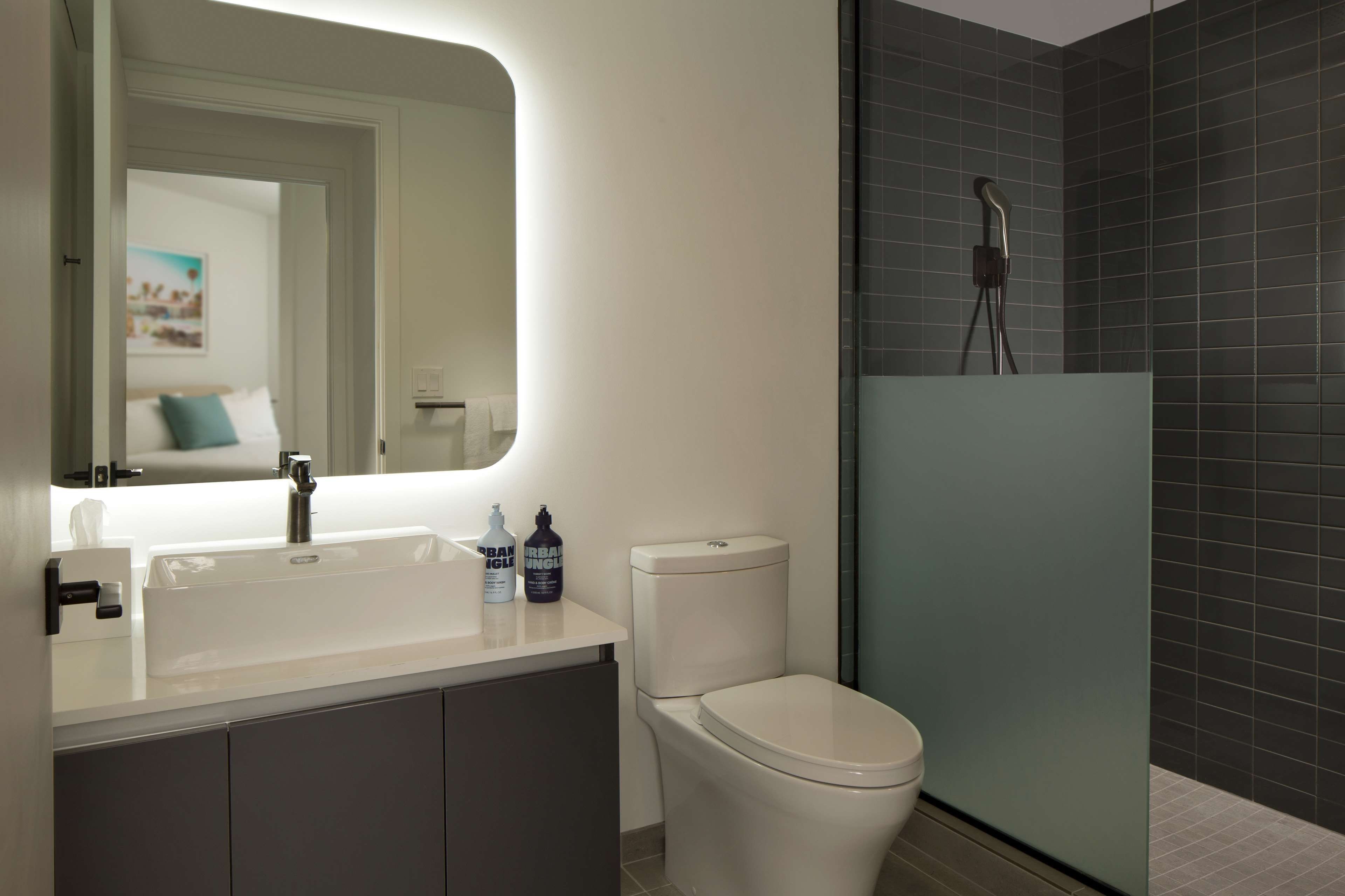 Un baño moderno con lavamanos blanco, inodoro y zona de ducha.