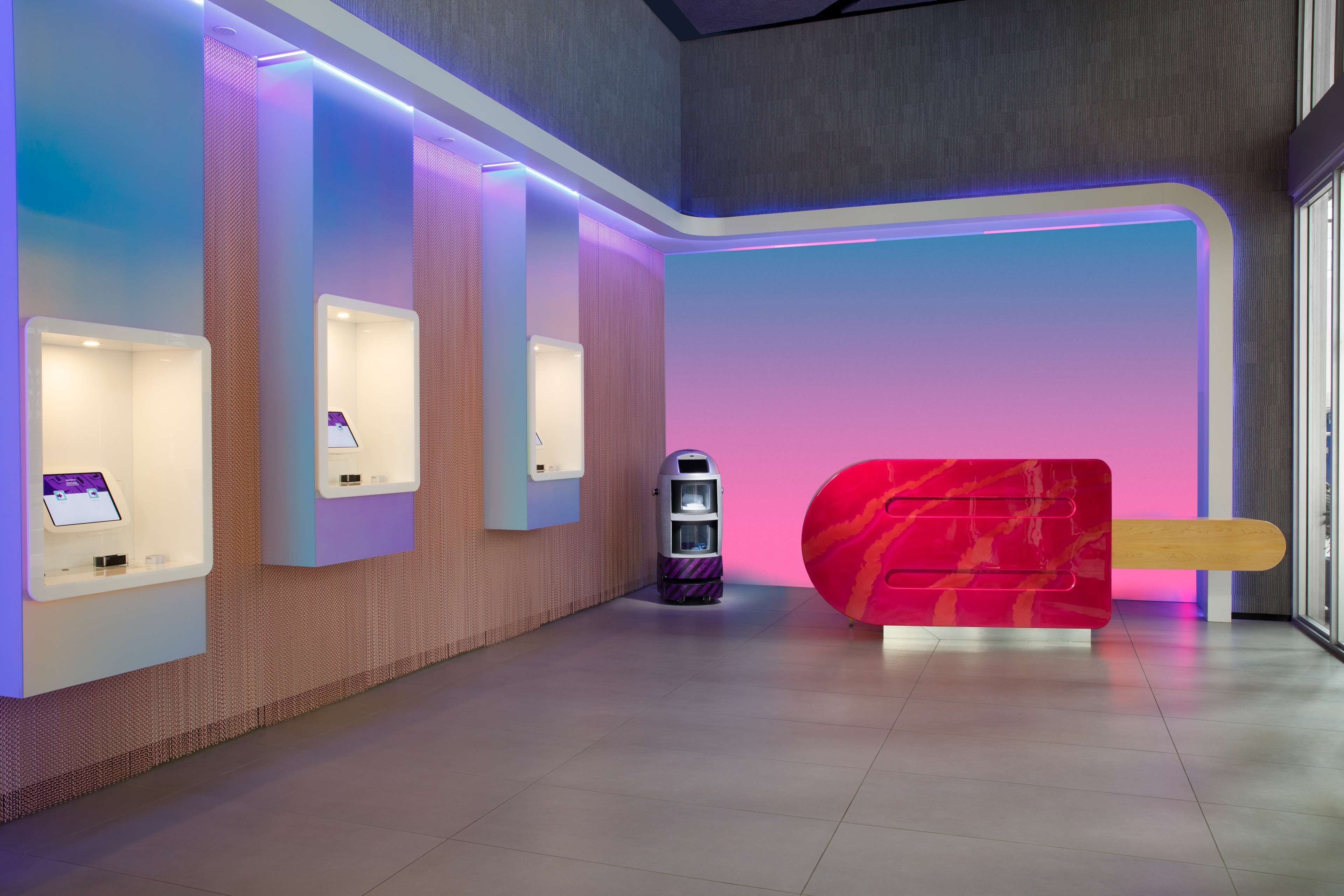 A modern interior with a reception desk, a vending machine, and a large red sculpture.