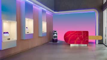 A modern interior with a reception desk, a vending machine, and a large red sculpture.