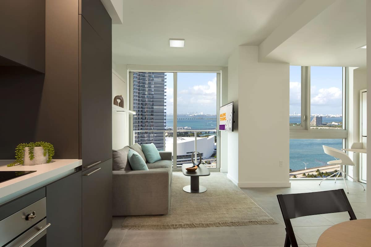 Un salon moderne avec un canapé, une table basse et une vue sur la ville et la mer.