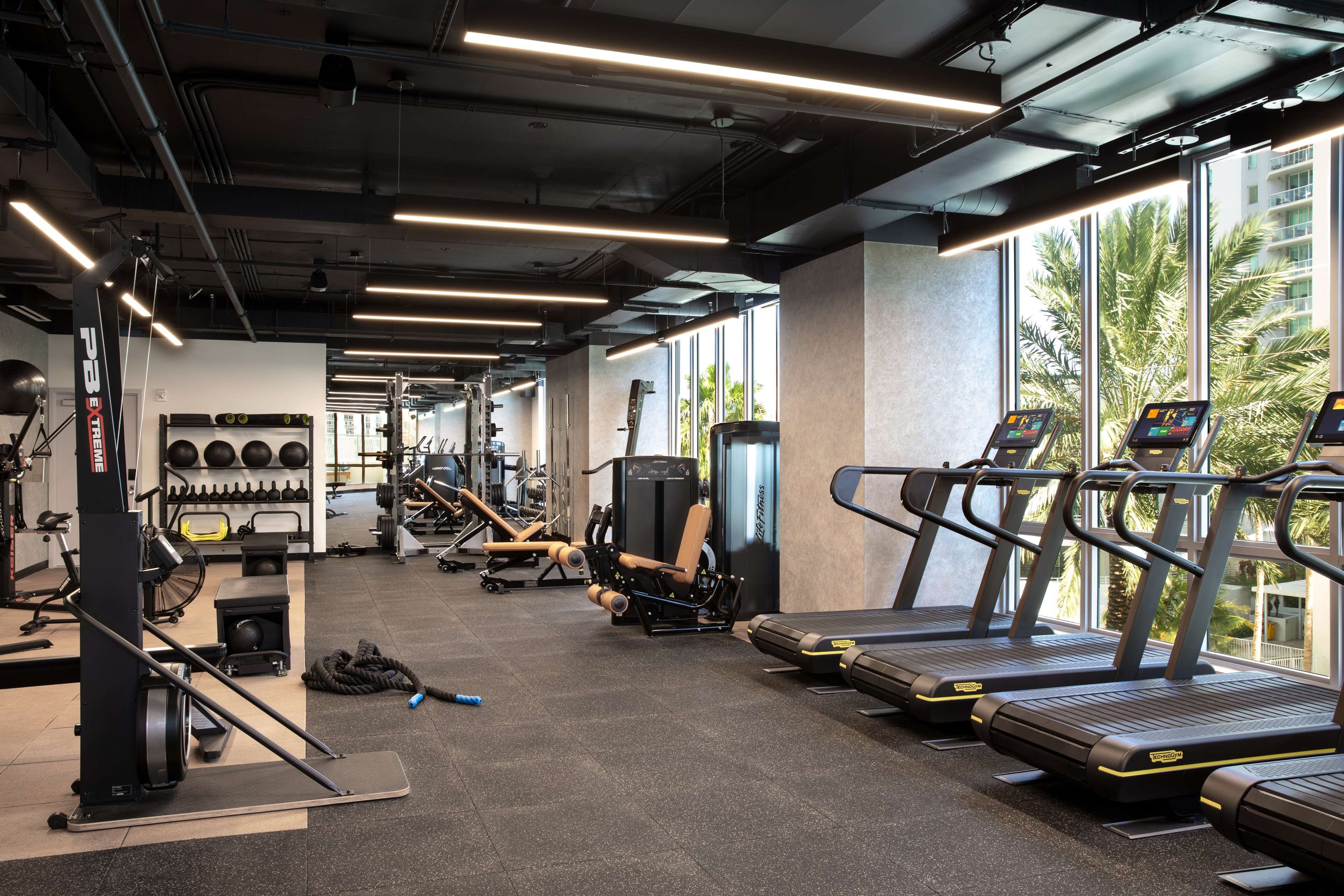 A gym with treadmills, weight machines, and a rowing machine.