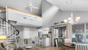 A spacious living area with a high ceiling, a dining table, and a kitchen in the background. - Cottage 187, Spacious, Closest Cottages to the Beach, Free Beach Chair Service (Miramar Beach)