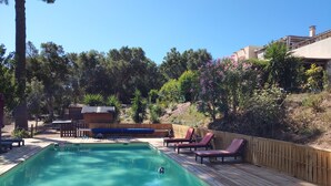 A rectangular pool with a wooden deck, surrounded by a wooden fence and trees. - Garden apartment in the heart of nature 10 min from the beach and 5 min from the river (Conca)