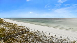 A beach with a wooden boardwalk, sandy dunes, and a clear view of the ocean. - Surf Dweller 610 is a Stunning Gulf Front 2 BR - sleep 6 by RedAwning (Fort Walton Beach)