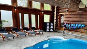 Ein Hallenbad mit Liegestühlen und einer Holzwand mit Schuhablage.