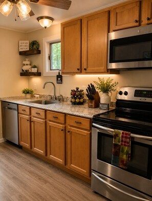 A kitchen with wooden cabinets, a stainless steel oven, a microwave, and a dishwasher. - Cozy Retreat in Masthope by Narrowsburg & Delaware (Lackawaxen)