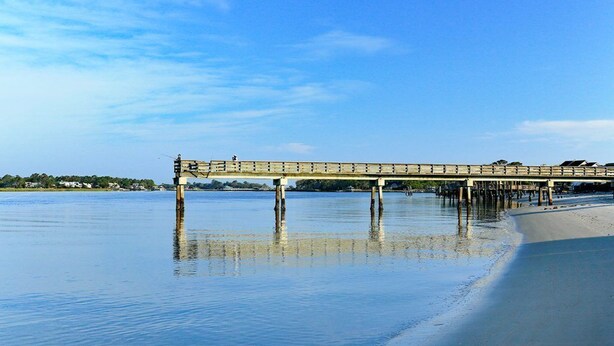 A pier extending into calm water with a clear sky above. - 1415 Butlers Ave. # 12 - Pool - Beach 1 block away (Tybee Island)
