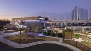 A modern TopGolf facility with a well-lit entrance, outdoor seating area, and a landscaped garden. - Coastal Farmhouse Comfort (Mt Pleasant)