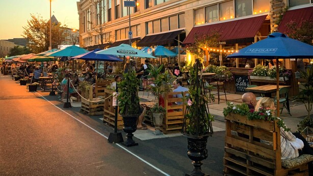 An outdoor market with wooden stalls and tables, surrounded by a building with large windows. - Studio w/ Kitchenette 2 Blocks to Beach & Main Ave | Near Asbury Boardwalk (Ocean Grove)