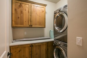 Un espace buanderie avec des armoires en bois, un lave-linge et un sèche-linge.