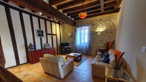 Uma sala de estar com lareira, dois sofás, uma mesa de centro e uma parede de pedra.