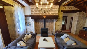 Una sala de estar acogedora con dos sofás, una mesa de centro blanca, una chimenea y un candelabro.