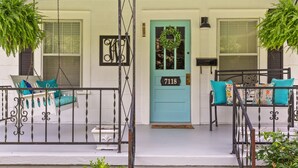 A porch with a teal door, a swing chair, and a bench with teal cushions. - Genevieve's Cottage! Totally Renovated with all the Charm! (Hixson)
