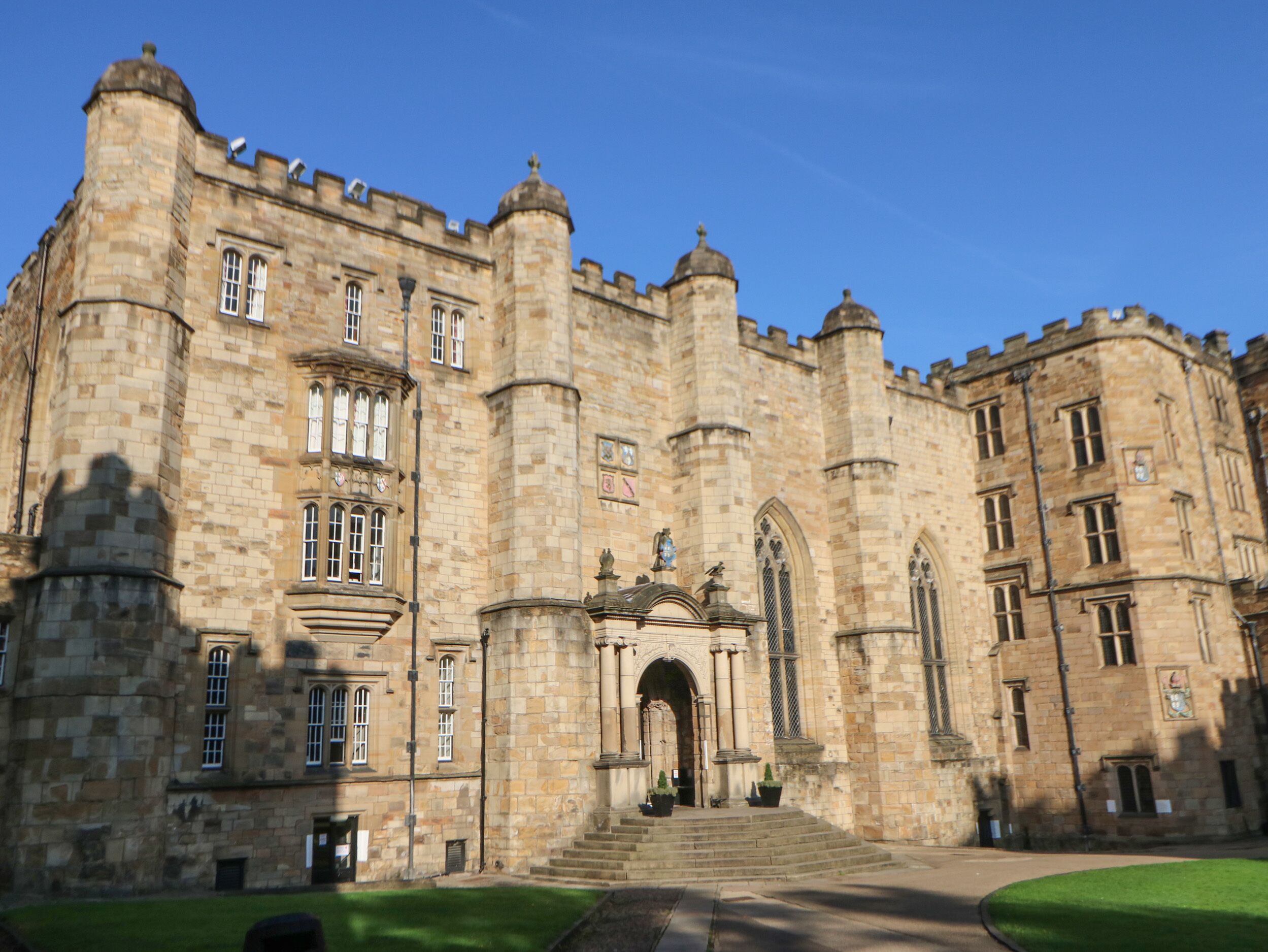 A large, historic stone building with a central entrance, multiple windows, and a symmetrical facade.