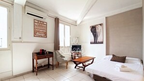 Ein Hotelzimmer mit Bett, Schreibtisch, Stuhl, Tisch und Fernseher.