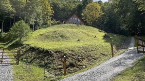 Una casa sobre una colina cubierta de hierba, con un camino de grava que la conduce.