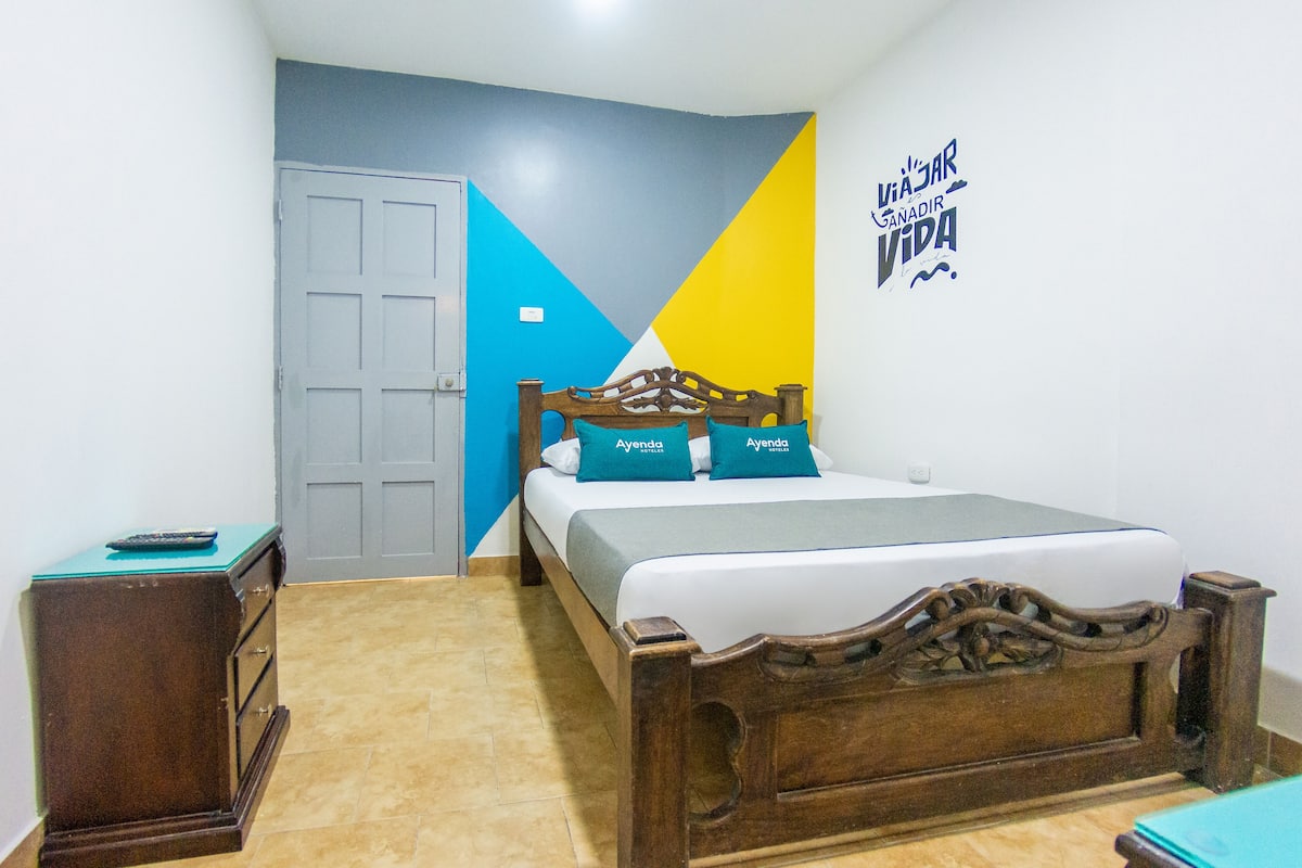 A bedroom with a wooden bed, a dresser, and a door.