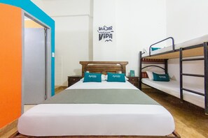 A room with a large bed, two bedside tables, a bunk bed, and a door with an orange frame. - Ayenda Centenario (Cartagena)