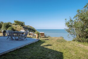 A deck with outdoor furniture overlooking a body of water. - Villa with magnificent unoverlooked sea view - 150m2 (Veulettes-sur-Mer)