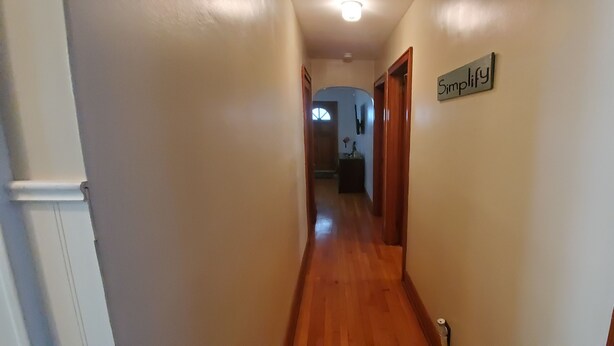 Un couloir étroit, doté d’un plancher en bois et orné d’une affiche sur le mur avec le mot « Simplifiez ».